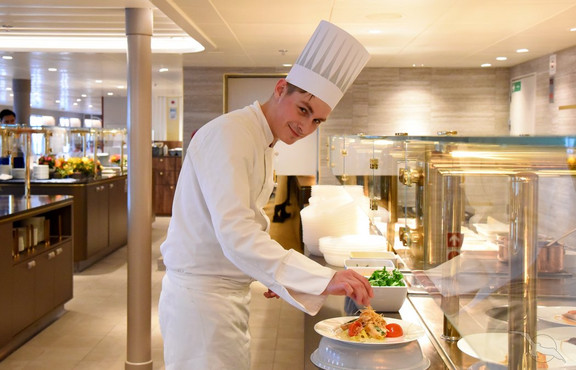 Koch bei der Arbeit an Bord von MS Amadea